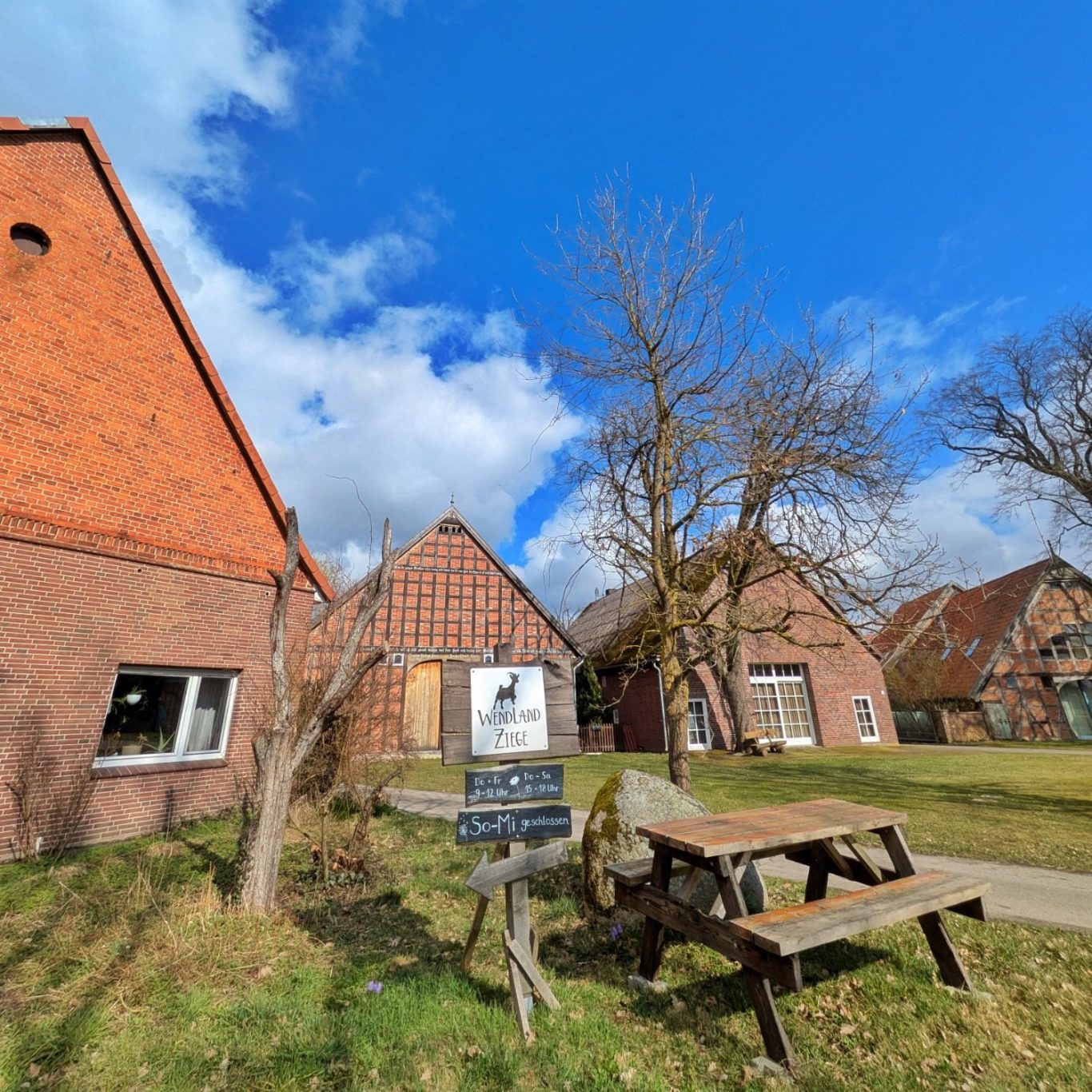 Sonniger Blick in den Innenhof des Biolandhofs Obermayer im Wendland mit Hofgebäuden