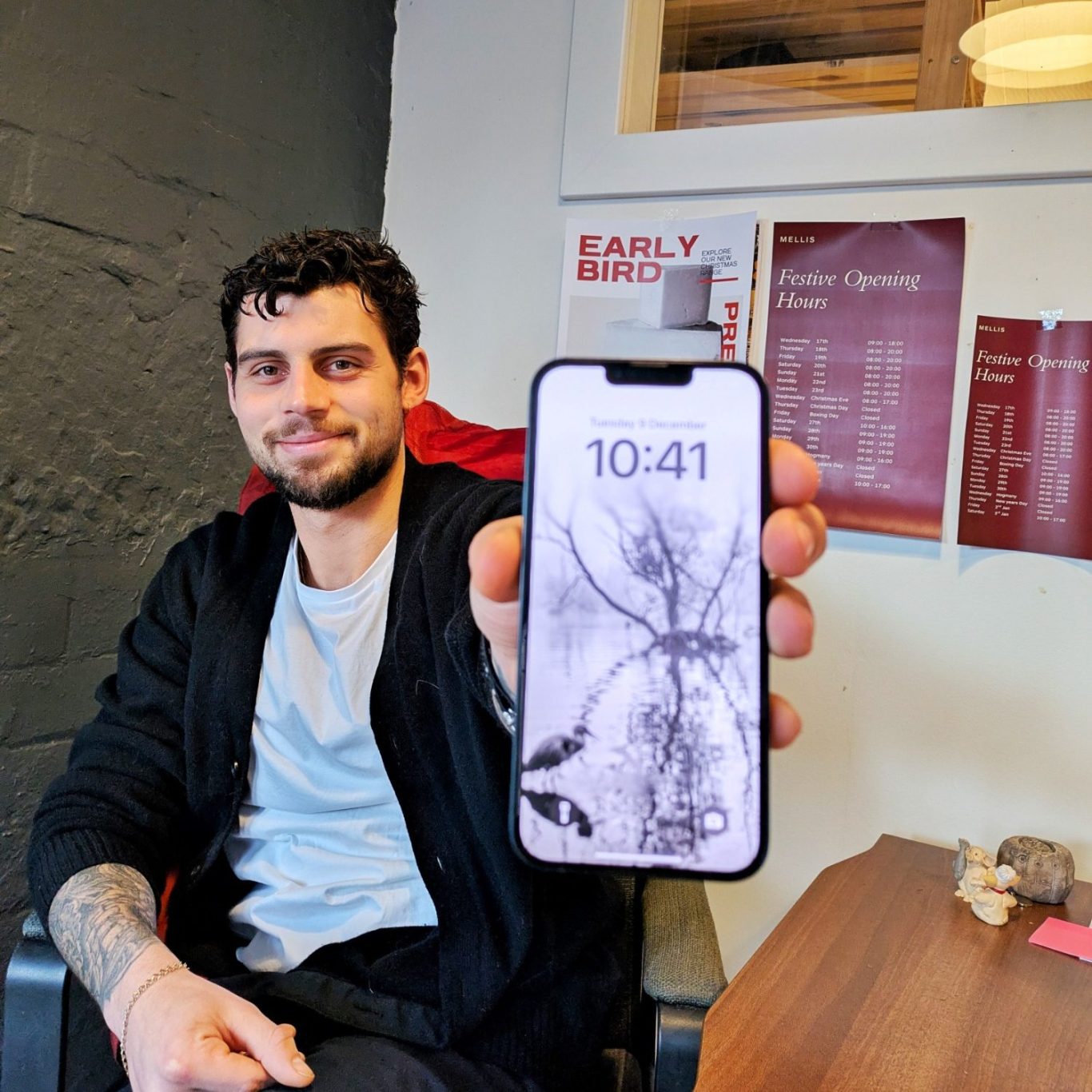 Rory Mellis im Büro der Old Lemonade Factory in Edinburgh, wie er auf seinem Smartphone eine Schwarz-Weiß-Aufnahme eines Reihers zeigt.