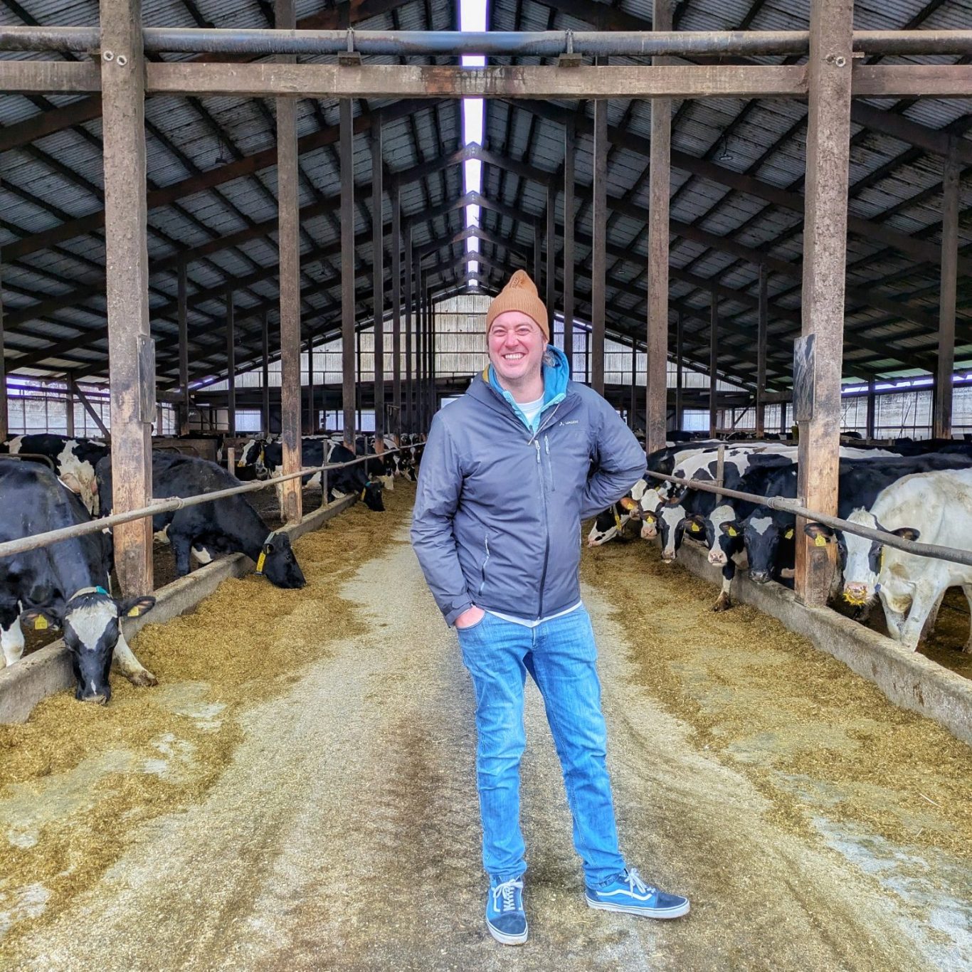 Thilo Metzger-Petersen posiert lachend im Kuhstalls auf dem Backensholzer Hof.