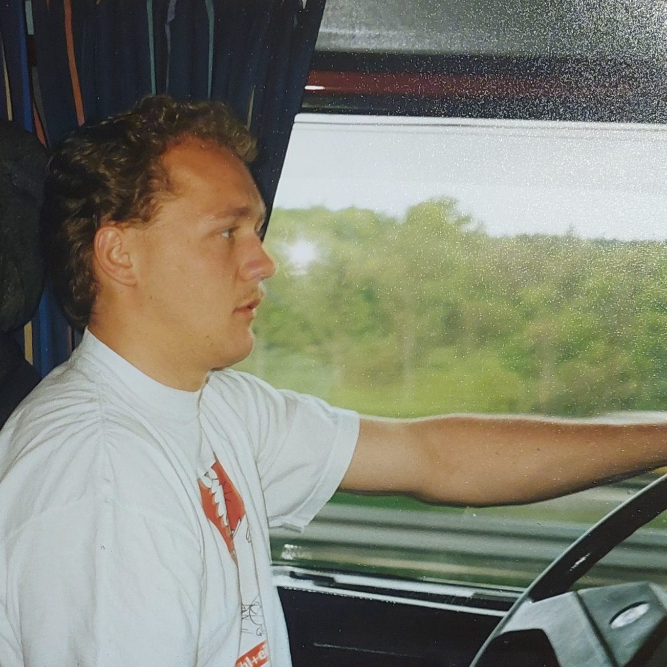 Historisches Foto von Peter Dörig im Fahrerhaus eines LKW während seiner Fernfahrerjahre, aufgenommen 1991.