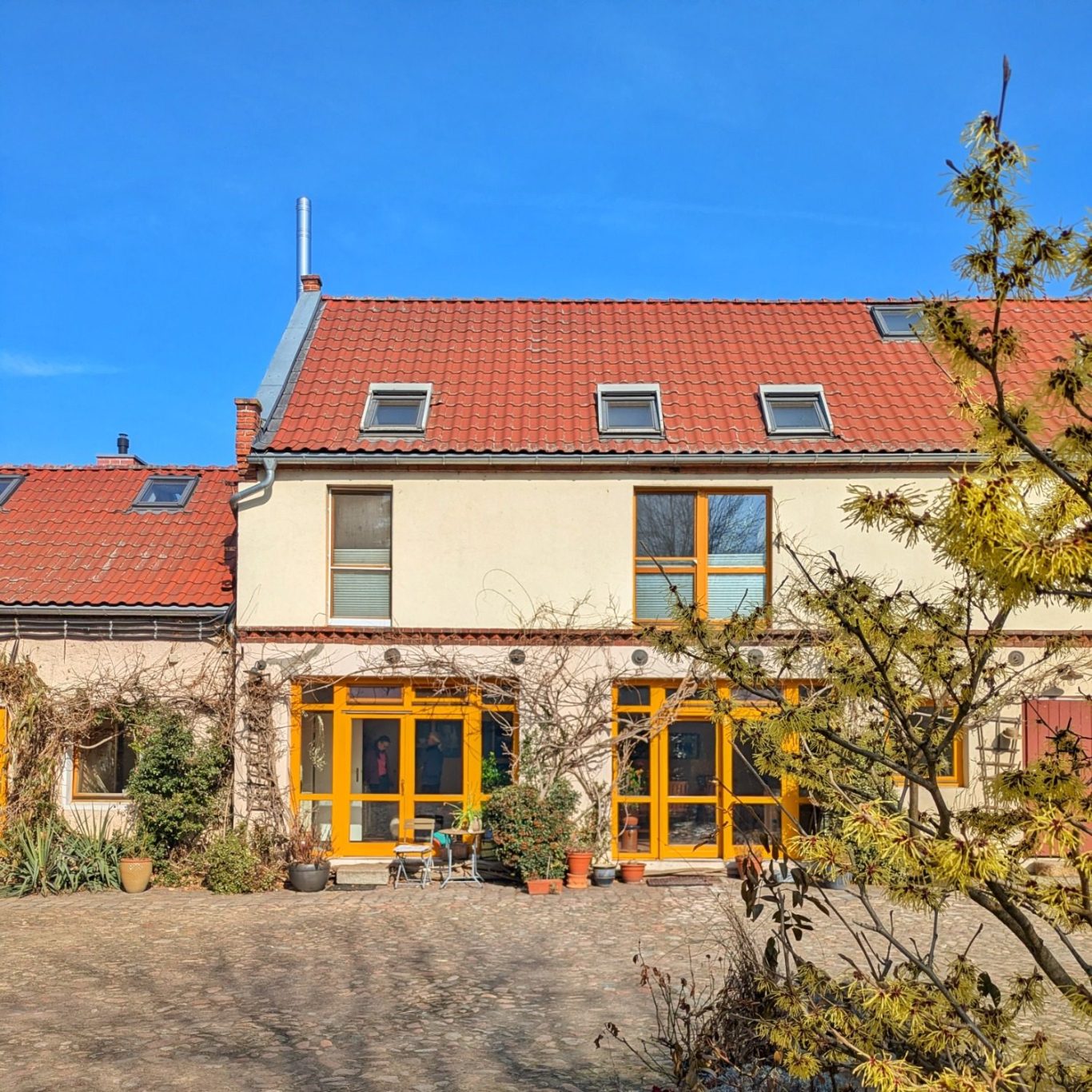 Sonniger Innenhof des Büffelhofs Bobalis in Jüterbog mit historischen Hofgebäuden.