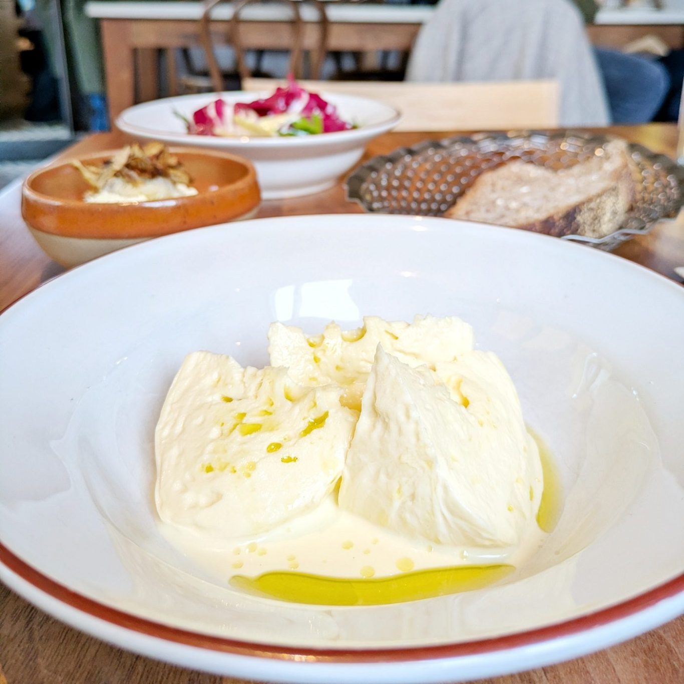 Frischer Mozzarella auf dem Teller im Restaurant Bæst, mit Olivenöl beträufelt und direkt aus der hauseigenen Käserei serviert.