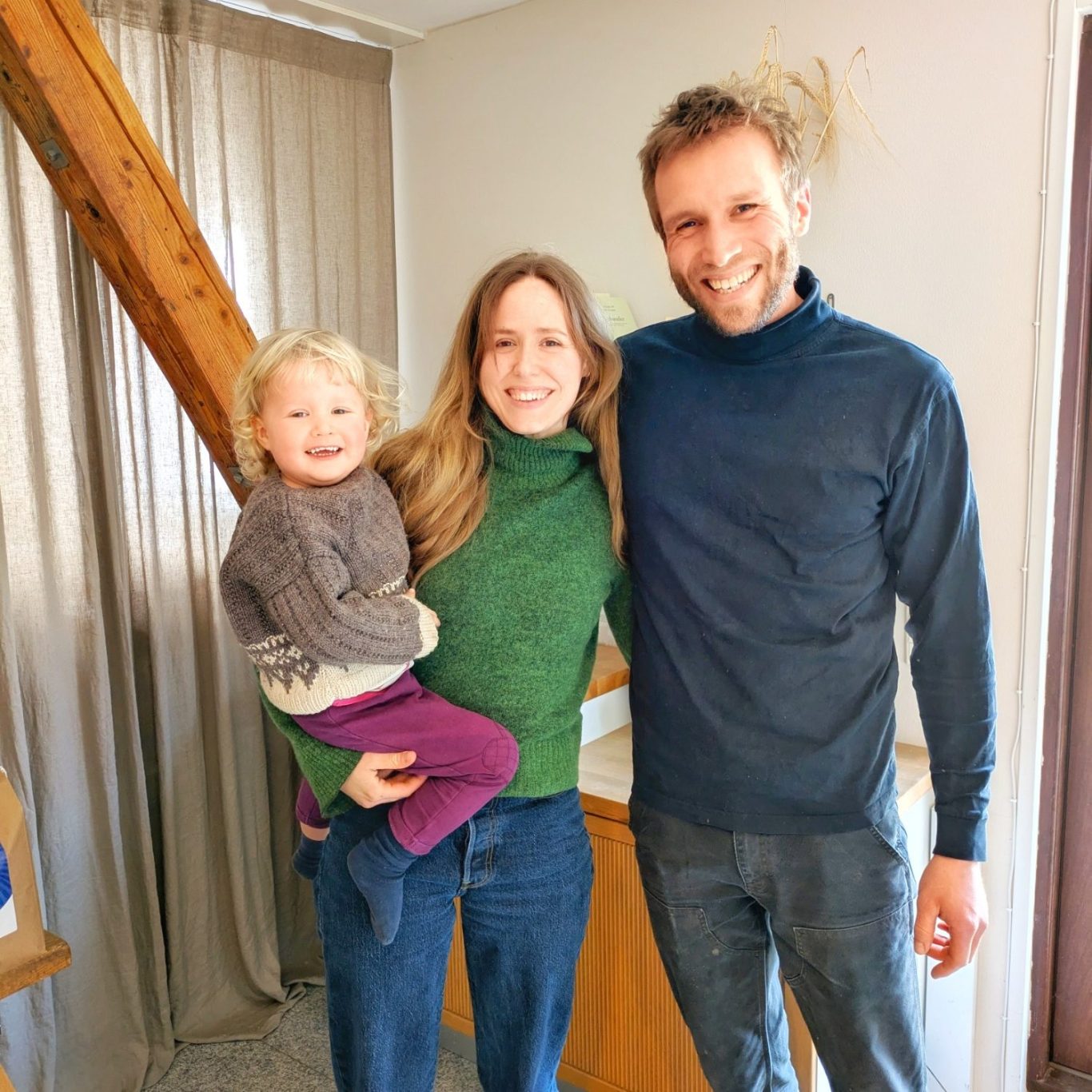 Marie Linea Østergaard und Mikkel Poulsen stehen mit ihrer Tochter Ida im Flur der Søtofte Gårdmejeri und blicken in die Kamera.