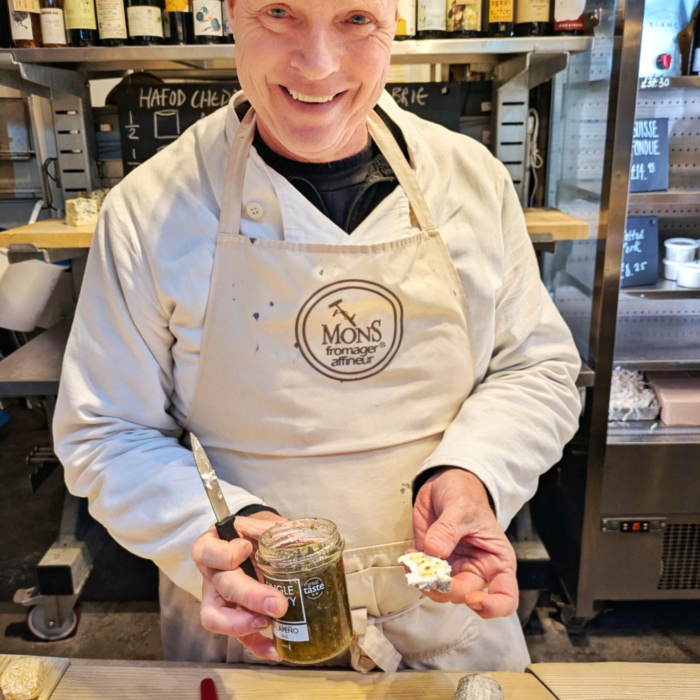 Autor und Cheesemonger Michael Finnerty steht strahlend am Stand von Mons im Borough Market, eine Käsekostprobe in der Hand