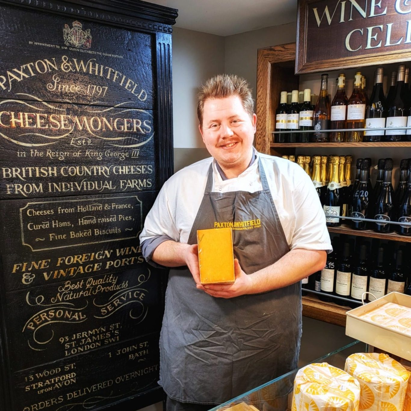 Robert Sweet steht im Laden von Paxton & Whitfield mit Red Leicester in der Hand.