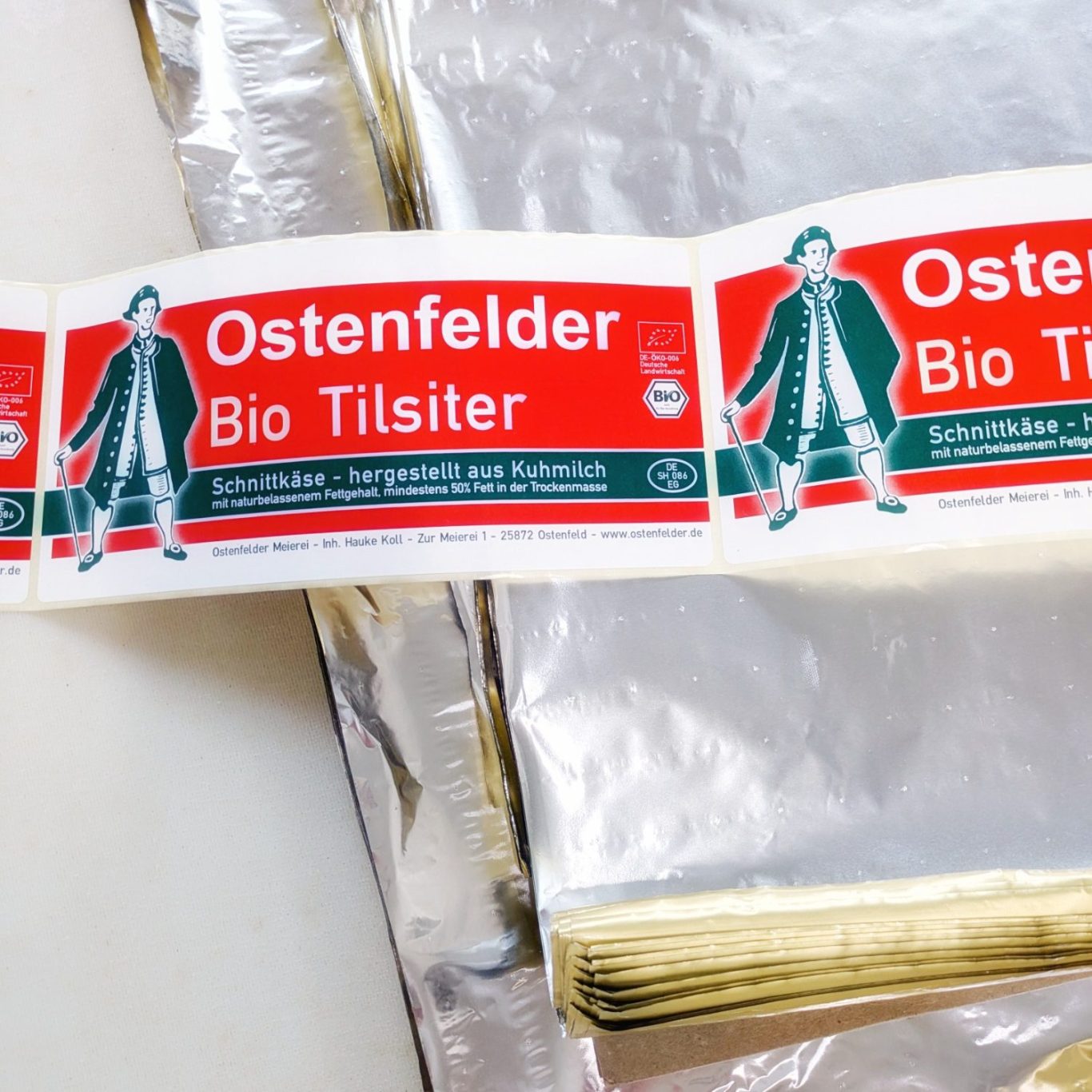 Verpackungsmaterial für Holsteiner Tilsiter Verpackungsmaterial für Holsteiner Tilsiter auf einem Tisch in der Ostenfelder Meierei.