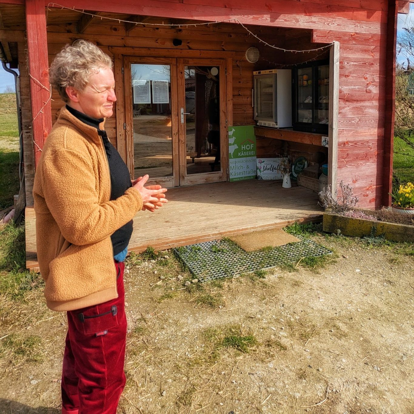 Sibylle Himstedt vor dem Hofladen vom Hof im Greth, Blick zur Seite im Wind