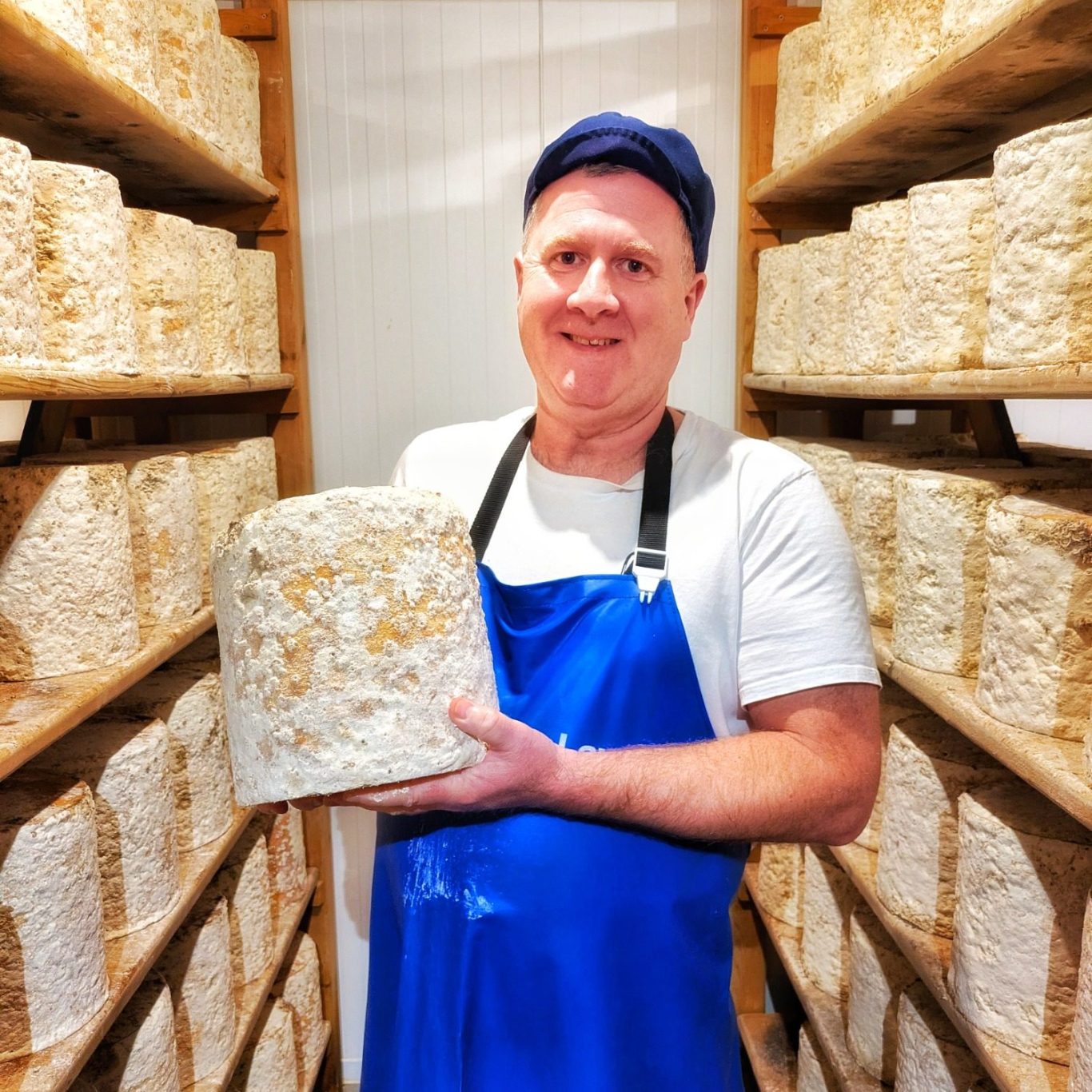 Joe Schneider hält einen Stichelton-Laib im Reiferaum der Stichelton Dairy auf dem Welbeck Estate in Nottinghamshire.