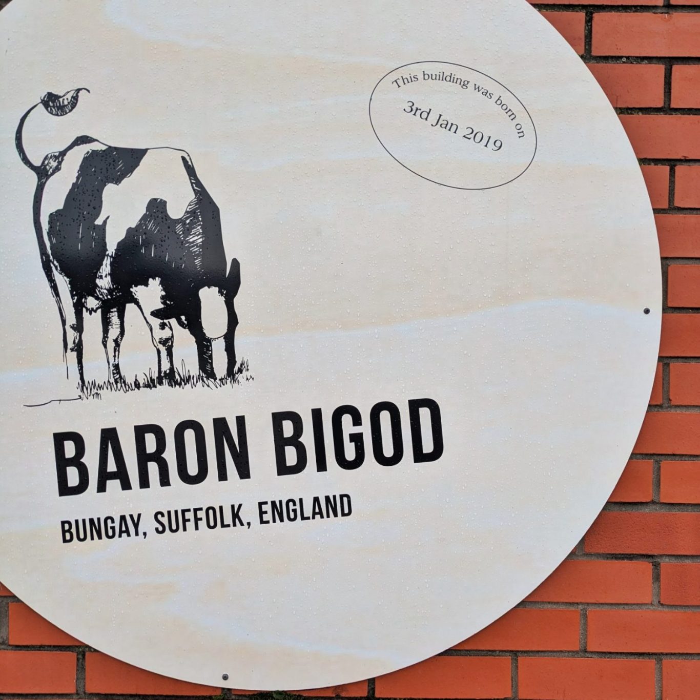 Siegel des Käses Baron Bigod an einer Außenwand der Fen Farm Dairy in Suffolk, England.