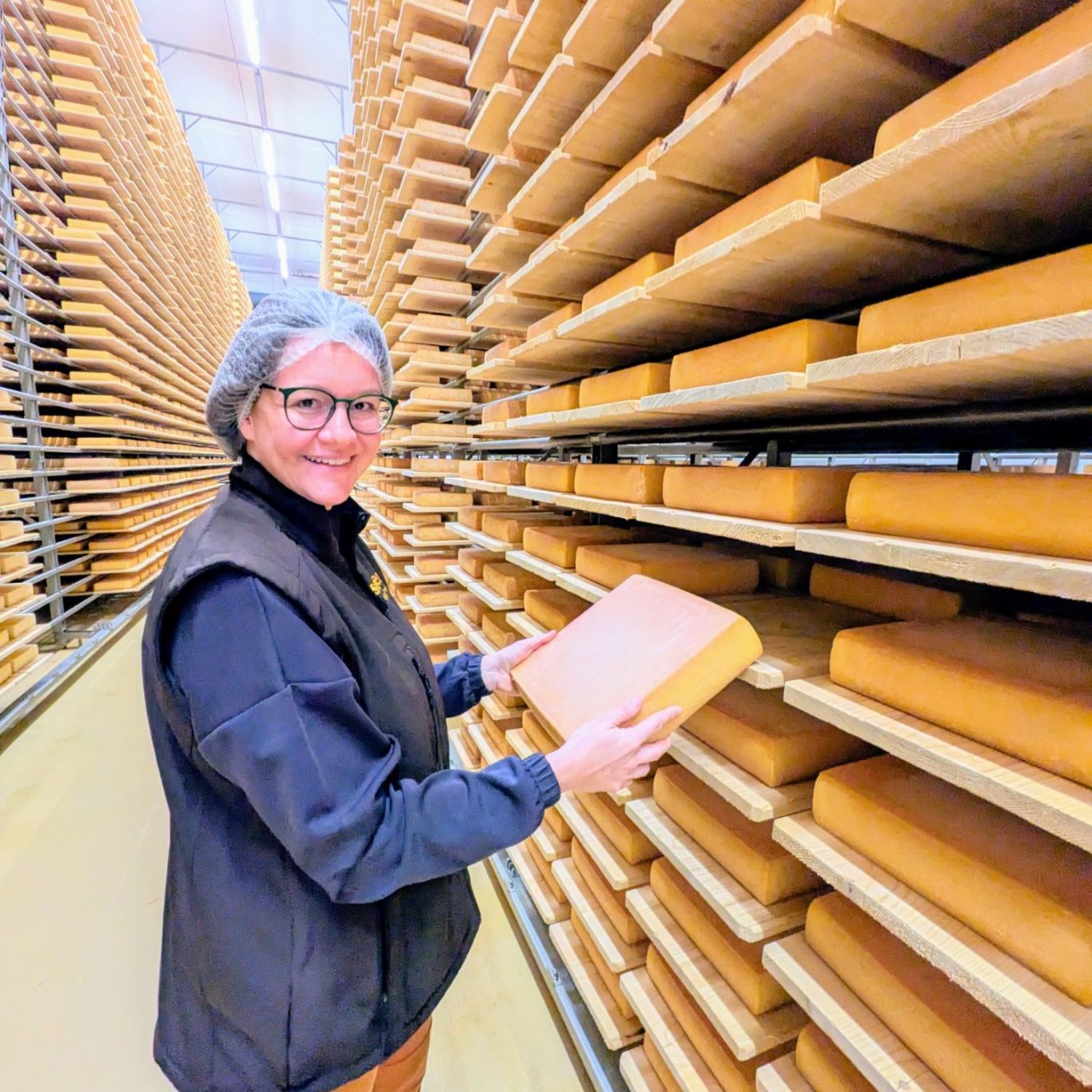 Noemi Decurtins zieht einen Raclette-Laib aus dem Reifelager der Seiler Käserei in Giswil